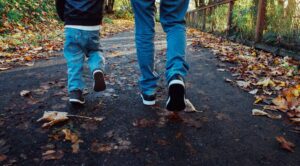 close up photo of a small child and parent walking outside